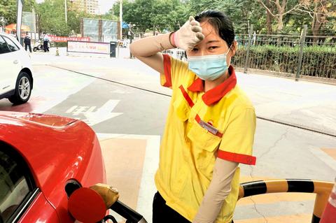 图4：高温下，汗水把工服浸湿了，头发也湿了，但天气再热 他们也在岗位坚守。图为加油员宋卡在一边加油一边擦汗。（贺志玲摄）.jpg