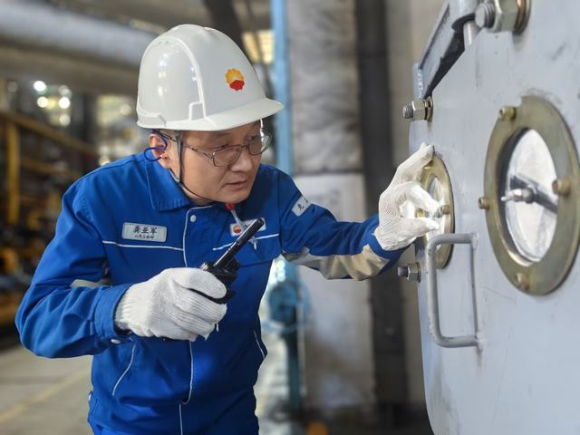 龚亚军正在检查给煤机下煤和皮带磨损情况（通讯员 丁恬甜）.jpg