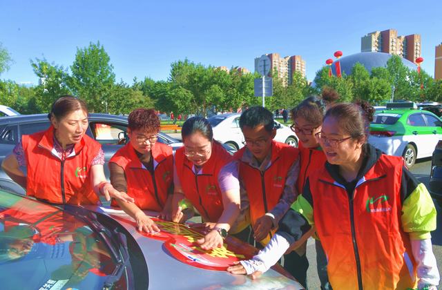 2025年5月29日，志愿者正在克拉玛依市大油泡城市广场给爱车张贴“爱心送考”车贴._2631.JPG