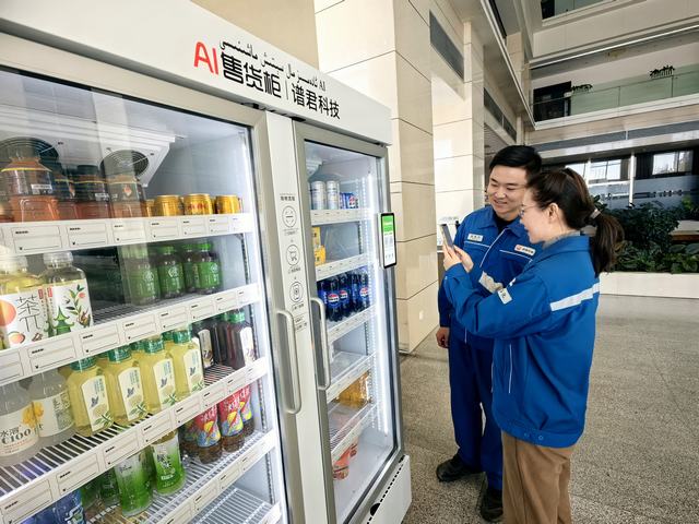 1763971433570232.jpg 员工正在自动售货机前扫码购买零食。丁恬甜 摄.jpg